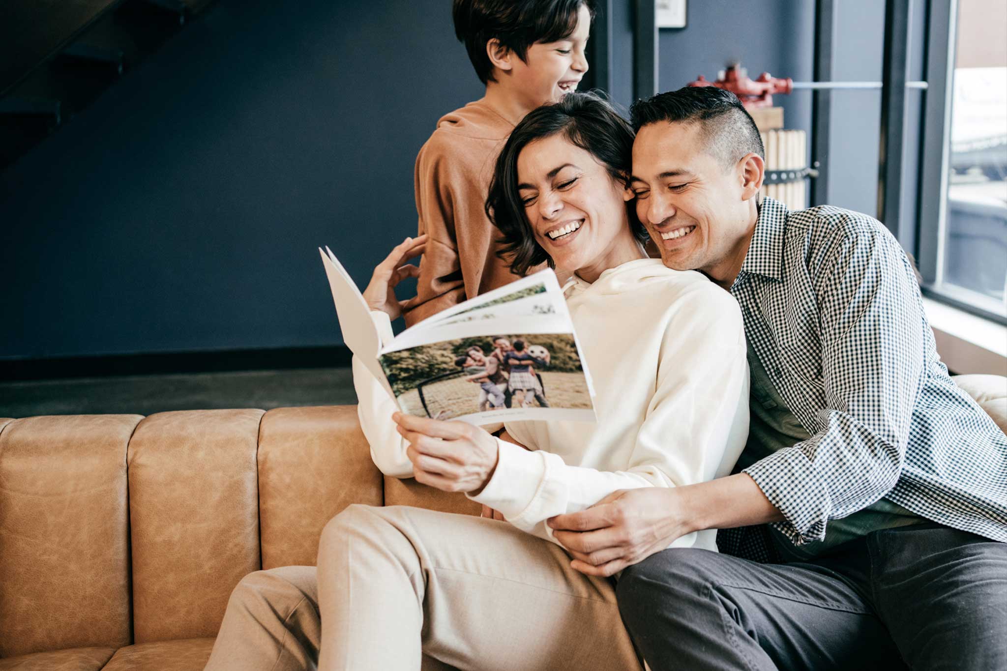 Gezin dat samen op een bank naar hun fotoboek kijkt